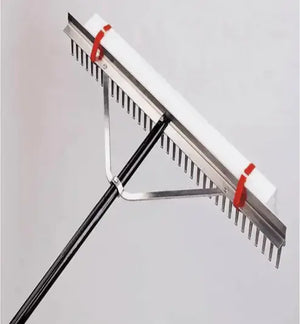 Metal rake with red handles on a gray background