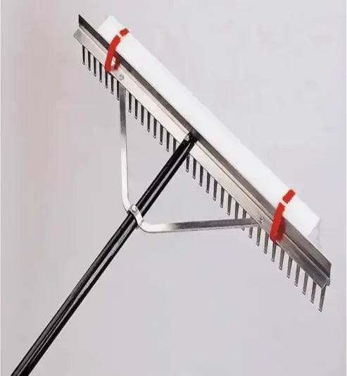 Metal rake with red handles on a gray background